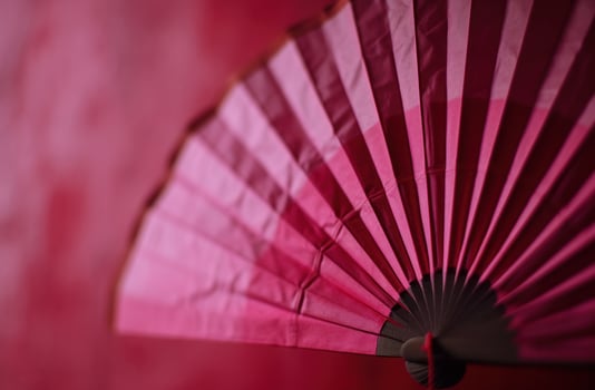 AI generated a pink origami fan hangs on a red background photo