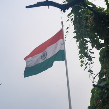 India flag flying high at Connaught Place with pride in blue sky, India flag fluttering, Indian Flag on Independence Day and Republic Day of India, tilt up shot, Waving Indian flag, Har Ghar Tiranga photo