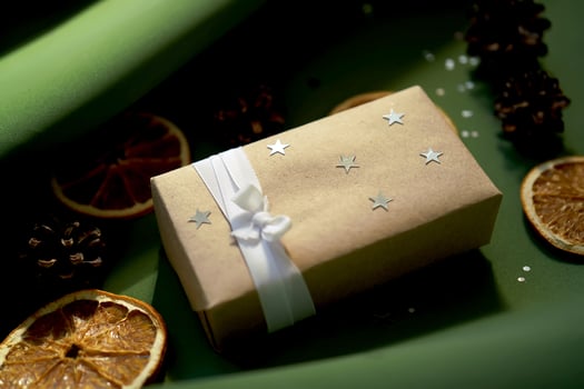 Christmas gift in craft paper on a green background. photo