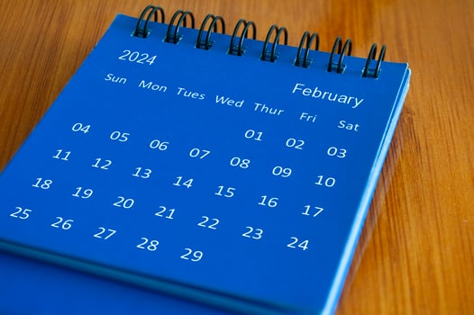 February 2024 table calendar on wooden desk. Time and calendar concept photo