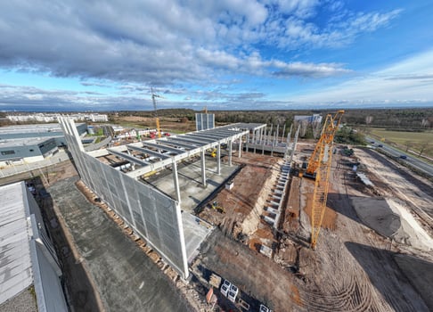 Drone image of a construction site of an industrial building with columns and beams and a heavy-duty crane photo