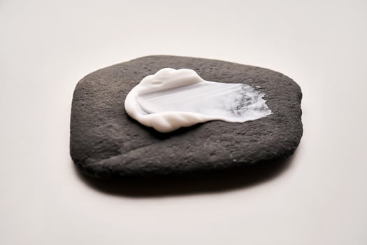 A smear of white cream on a black stone. photo
