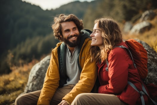 AI generated Happy young couple sitting on top of a mountain and looking at each other, Carefree couple enjoys in view while taking break during hiking in nature, AI Generated photo