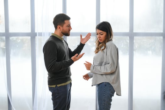 An agitated and upset husband shouts and looks at his wife, a quarrel between spouses. Family misunderstanding, quarrel photo