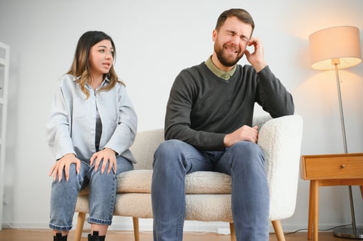 Family quarrel, man and woman sitting on sofa at home. angry woman yells at her husband photo