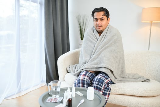 Sick young hindu man feeling bad in the morning, sitting on bed photo