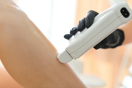 Beautician waxing female legs in spa center photo