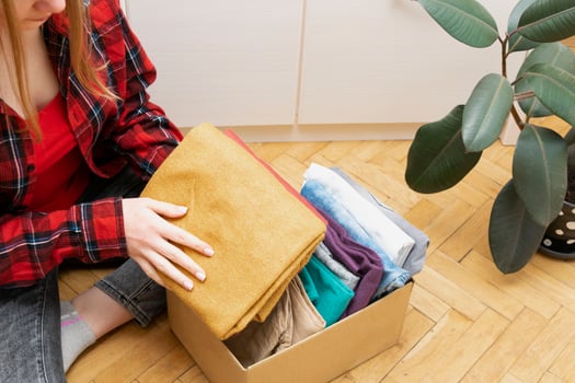 Woman packs clothes in boxes for donating. photo