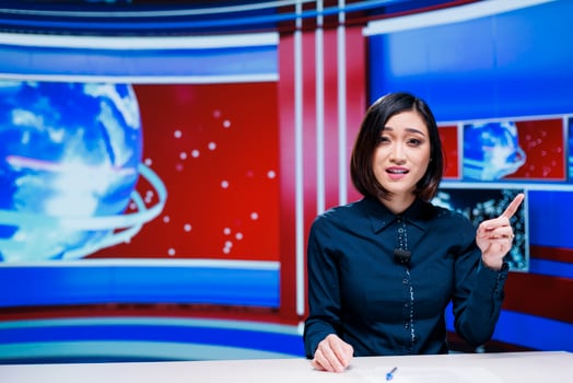 Asian tv host presenting daily news on live broadcast, discussing about latest events happening in the city. Journalist reading media headlines and giving important information to viewers. photo