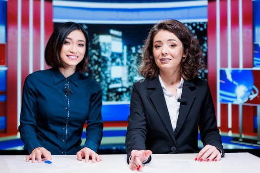 Newscasters team read headlines live on television program, hosting night talk show filled with exclusive media information. Presenters team creating international reportage global issues. photo