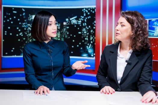 Diverse women presenters talk about latest news live on television broadcast, hosting late night show filled with exclusive details and information. Newscasters team presenting global issues. photo