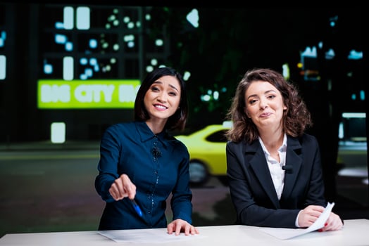 Newscasters team hosting night show in studio, reporting current news topics from media outlets. Diverse presenters women addressing all celebrity scandals and creating tv content. photo