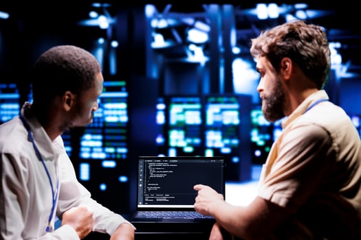 IT developers coworkers writing script code in server room on laptop terminal. Teamworking programmers doing maintenance work in technologically advanced data center updating racks software photo