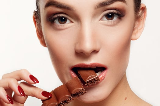 Lovely smiling teenage girl eating chocolate photo