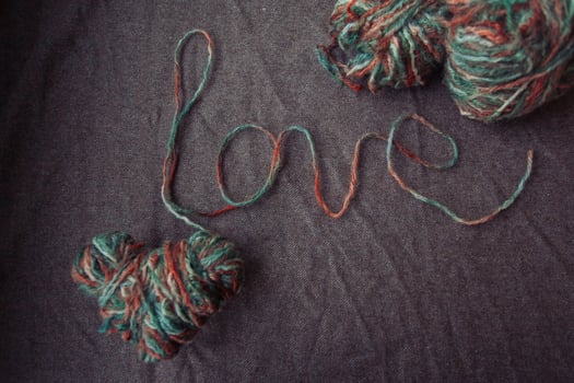 love written of wool yarn on a brown background photo
