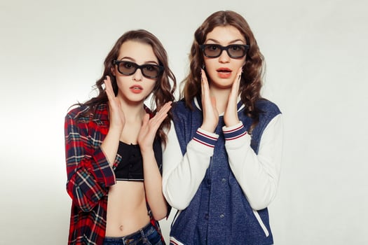 Two attractive smiling girl in a 3d-glasses photo