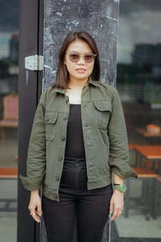 Young Beautiful Asian Woman Wearing Jacket And Black Jeans Posing Outdoors photo