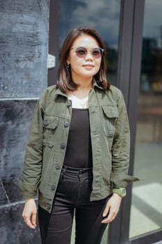 Young Beautiful Asian Woman Wearing Jacket And Black Jeans Posing Outdoors photo