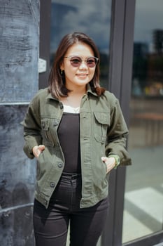 Young Beautiful Asian Woman Wearing Jacket And Black Jeans Posing Outdoors photo