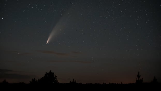 Comet NEOWISE moves across the night sky among the stars photo