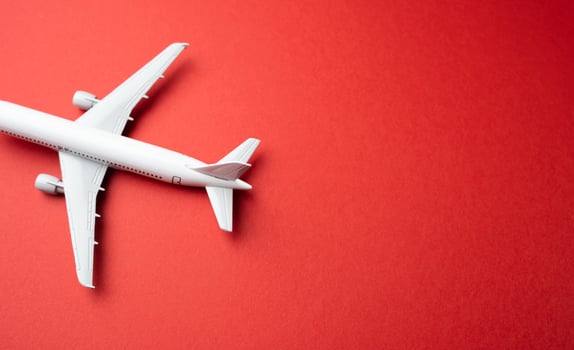 White passenger airplane on a red background. Booking flight tickets. Planning your trips. Additional service at airports. Arrival and departure. Business and tourism. Airline. photo