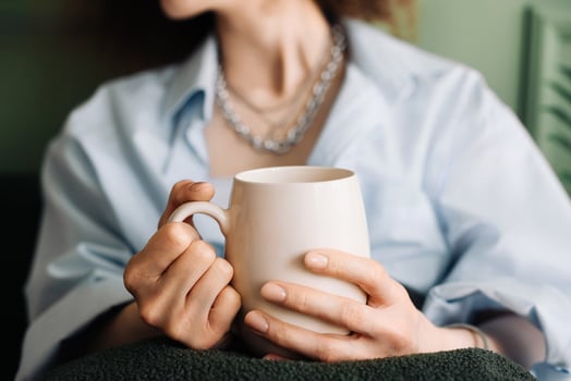 Millennials young woman enjoy relaxing and a cup of tea on the couch in the interior of the living room, cropped photo