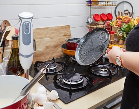 Hostess Cooking Delicious Pancakes on Gas Stove Skillet at Home photo