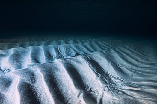 Tropical clear blue ocean  with sand bottom on night. Underwater view with artificial light photo