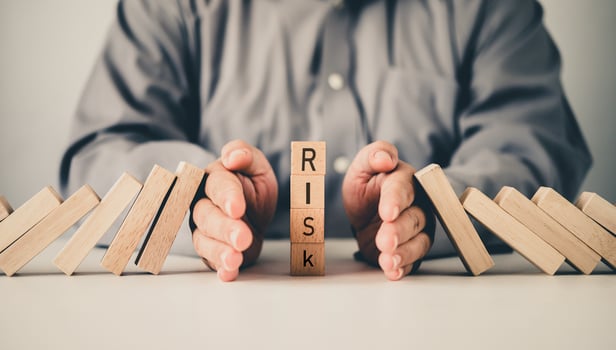 close-up hand The hand of a businessman who is stopping or preventing a falling block.Risk protection concept,Eliminating the risk photo