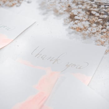 wedding invitation on the table with a bouquet of white roses and a blue ribbon. Wedding invitation mockup with dry flowers on white wooden background photo