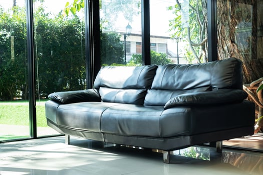 Cozy black leather sofa in composition with clear glass window in living room and sunlight with green garden outside, Cozy Interior concept ,minimal style photo