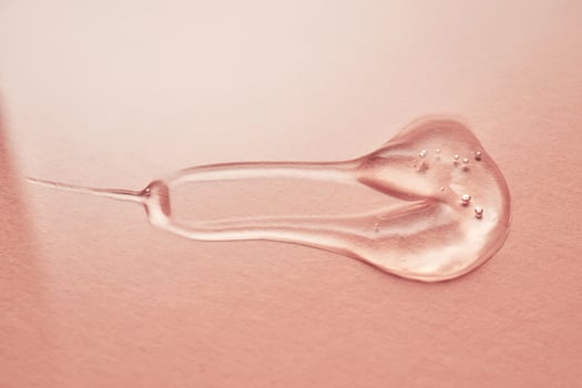 A drop of transparent cosmetic gel on a pink background. photo
