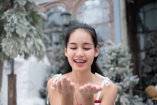 Portrait of teenage girl in a red dress relaxed and smiling in a snowy yard. photo