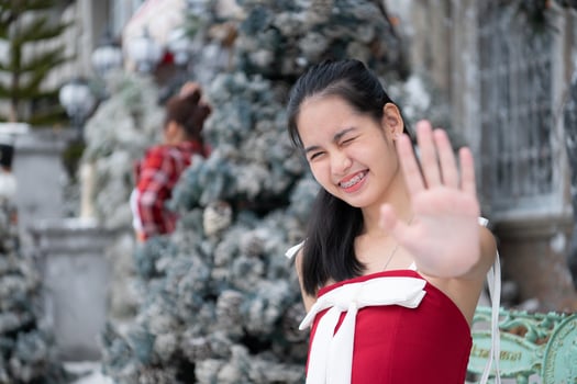 Portrait of teenage girl in a red dress relaxed and smiling in a snowy yard. photo