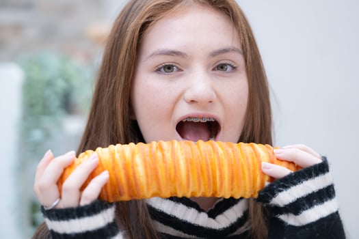 Portrait of Teenage girl eating bread in the kitchen at home photo