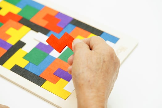 Asian elderly woman playing puzzles game for treatment dementia prevention and Alzheimer disease. photo