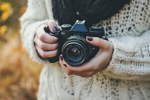 AI generated female hands holding a camera photo