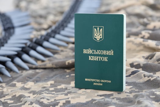 Ukrainian military ID on fabric with texture of pixeled camouflage. Cloth with camo pattern in grey, brown and green pixel shapes with Ukrainian army personal token photo