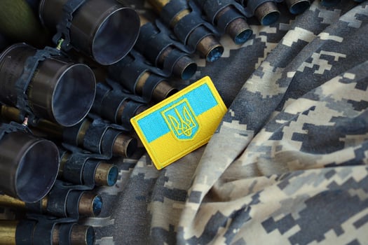 Ukrainian symbol on machine gun belt lies on ukrainian pixeled military camouflage photo