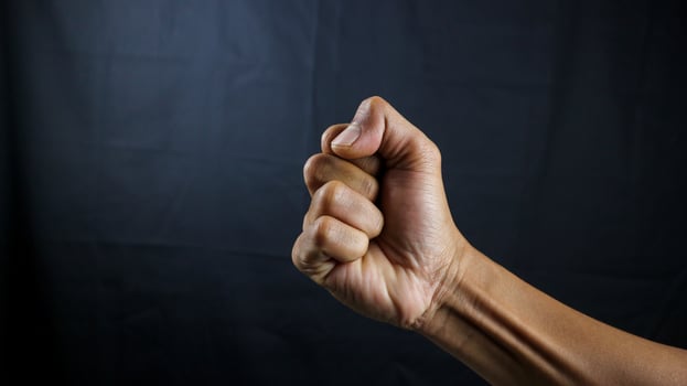Counting, aggression, brave concept. Black male fist, clenched hand, strong male man raised fist power, protest, fist ready to fight isolated on black background. photo