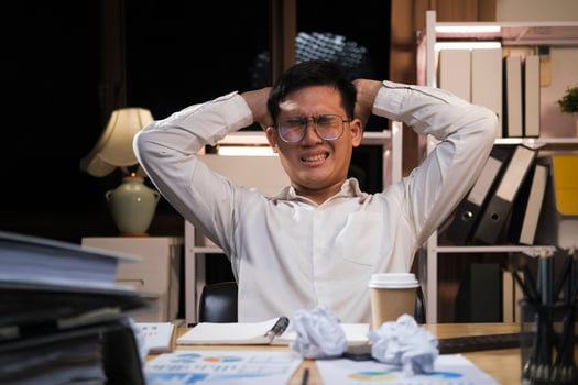 Young businessman working overtime on a desk at night. photo