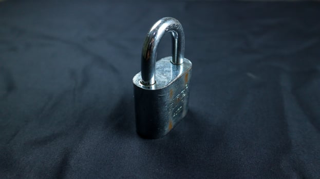 Semarang, 17 March 2023 - Locked Silver Padlock on the black background. photo