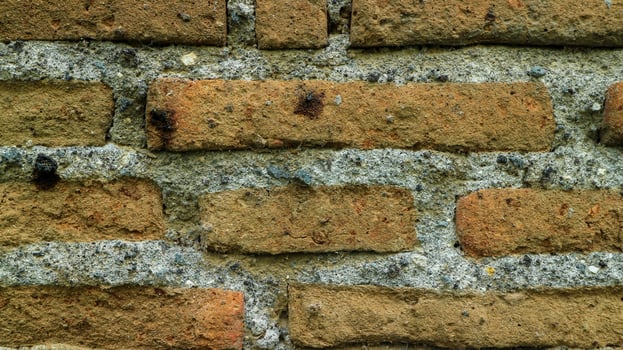 Close up photo of the texture of an old weathered brick wall. Macro photo background