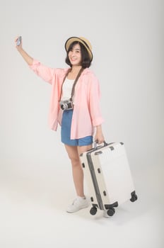 Young happy asian tourist woman over white background studio, travel and holidays concept. photo
