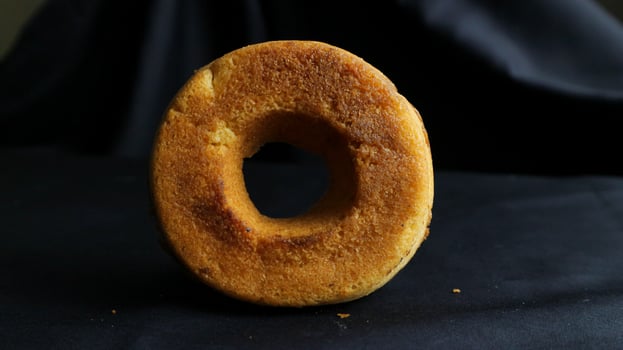 Fresh tasty colored donuts with sprinkles on black background photo