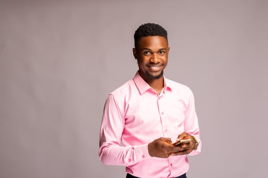 handsome man in isolated over white background smiling as he operates his phone photo
