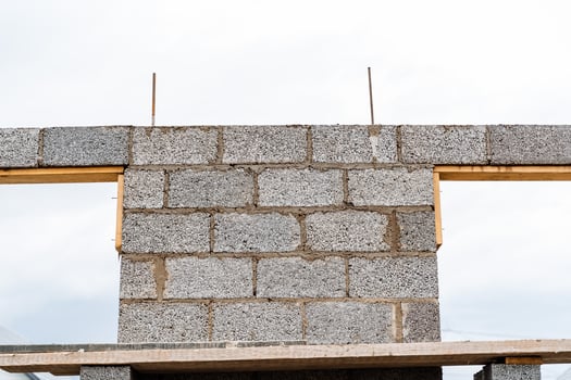 cinder blocks of gray concrete are neatly stacked in a pile, slender rows of bricks, material for building a house photo