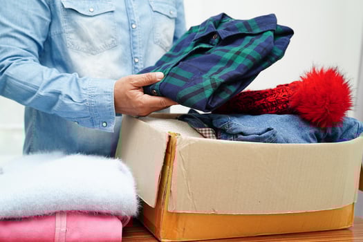 Clothes donations in cardboard box for volunteer. photo