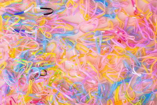 Colorful elastic rubber bands isolated on pink background. Colorful children's hair bands, flexible, made of para rubber. photo