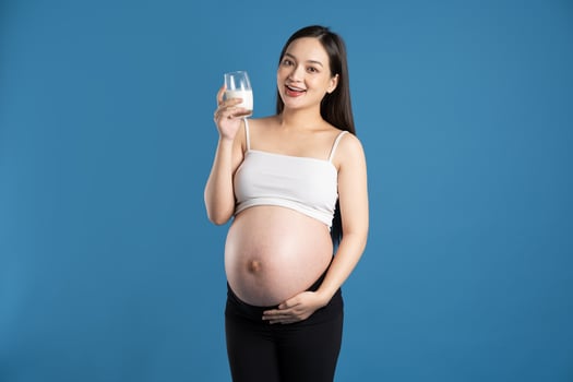 Portrait of pregnant asian woman, isolated on blue background photo